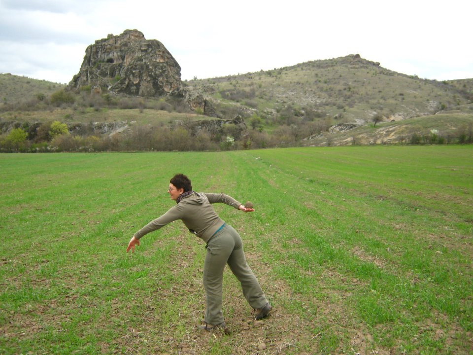 Discobolus with volcanic bombs in front of Cocev kamen, archaeological site and sanctuary. Location was in use from prehistory until late middle ages and it is a part of the tourist offer in Kartovo region